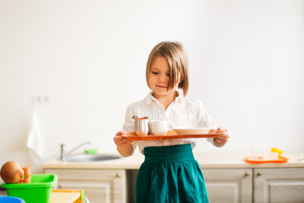 image of a child carrying a tray in Montessori.