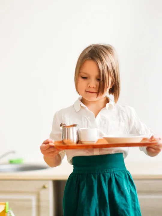 image of a child carrying a tray in Montessori.