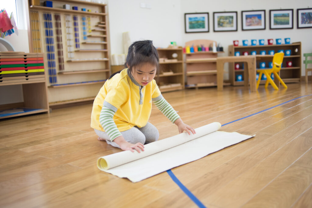 image of child in Montessori classroom to prepare for a Montessori work cycle.