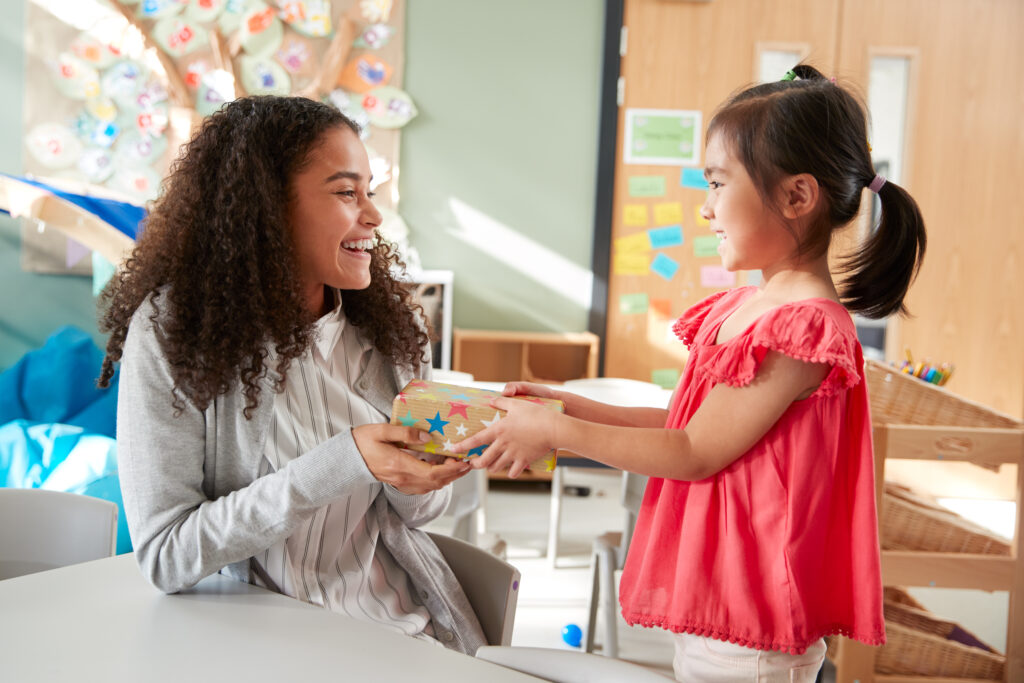 image of a child giving a montessori teacher a gift.