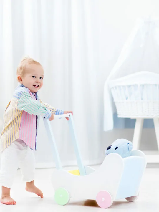 image of child pushing a wooden push walkers.