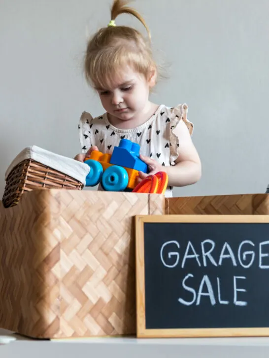 image of child looking through garage sale box for cheap montessori toys.