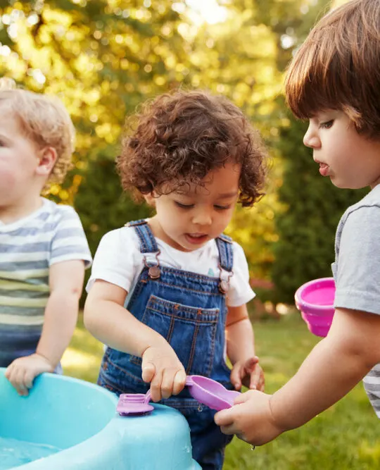 image of toddlers playing with water tables.
