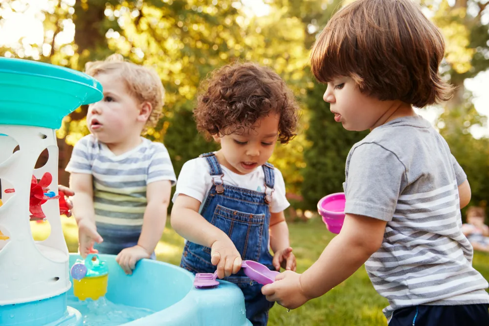 image of toddlers playing with water tables.