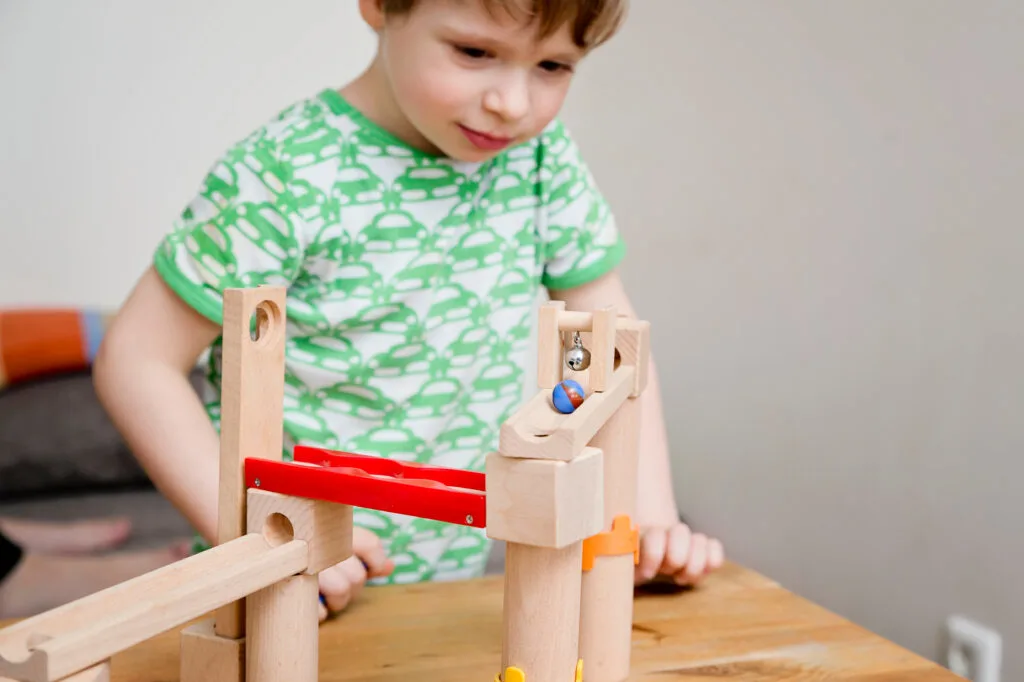 image of child playing with wooden marble runs.