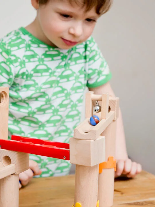 image of child playing with wooden marble runs.