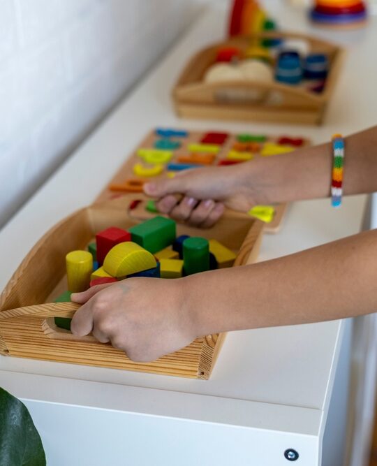 image of Montessori trays lined up with boy grabbing tray.