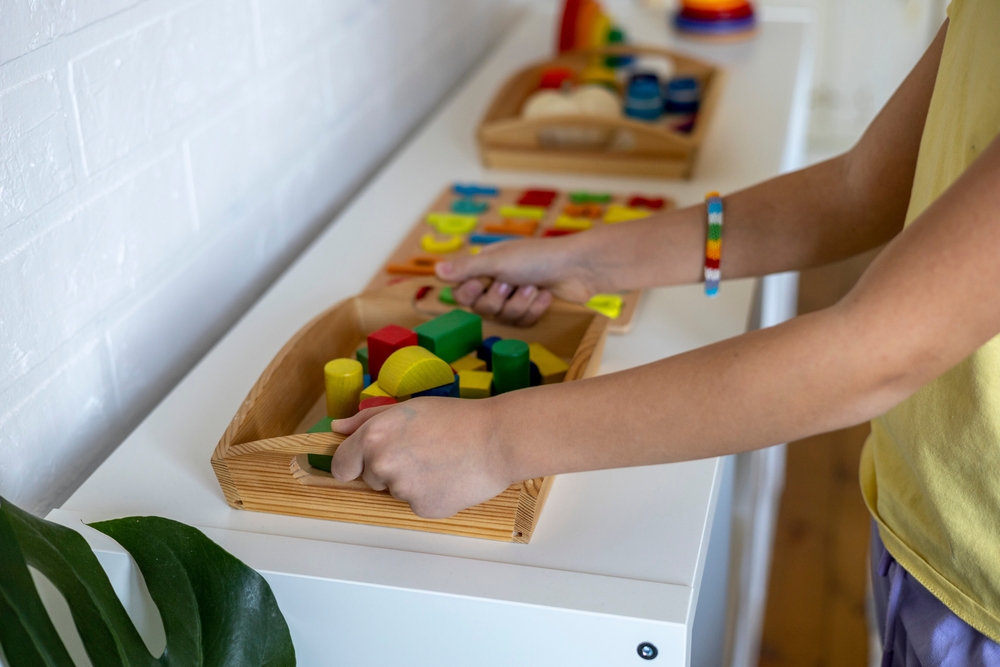 image of Montessori trays lined up with boy grabbing tray.