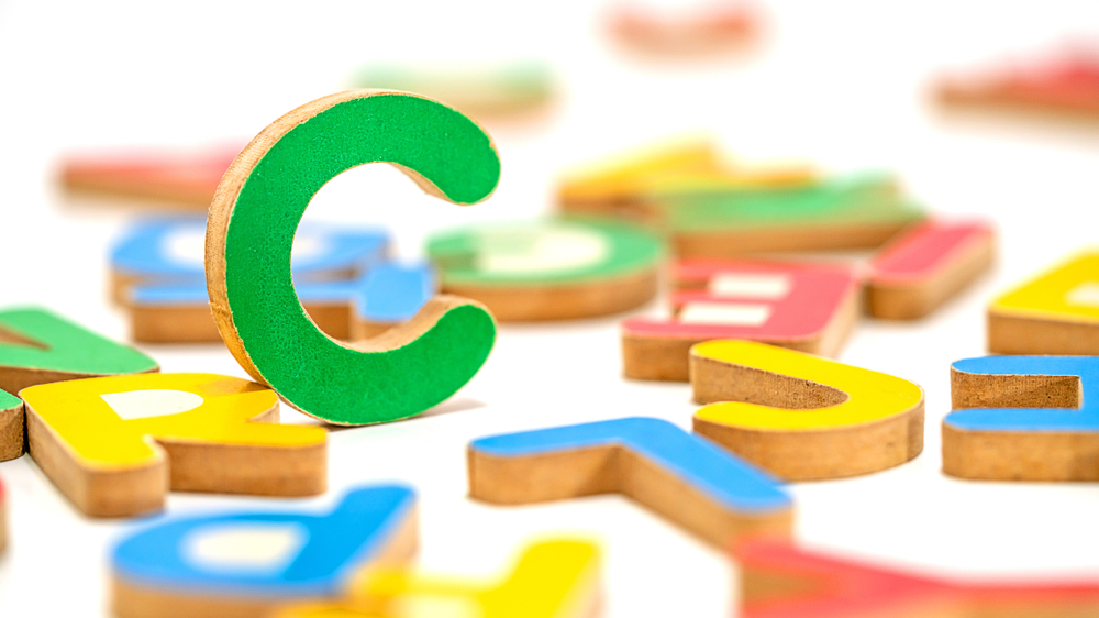 Image of randomly colored toys, including the letter c, which is standing.