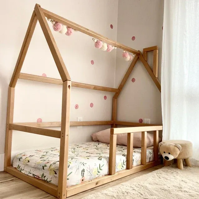 Image of Montessori house bed with wooden rails.