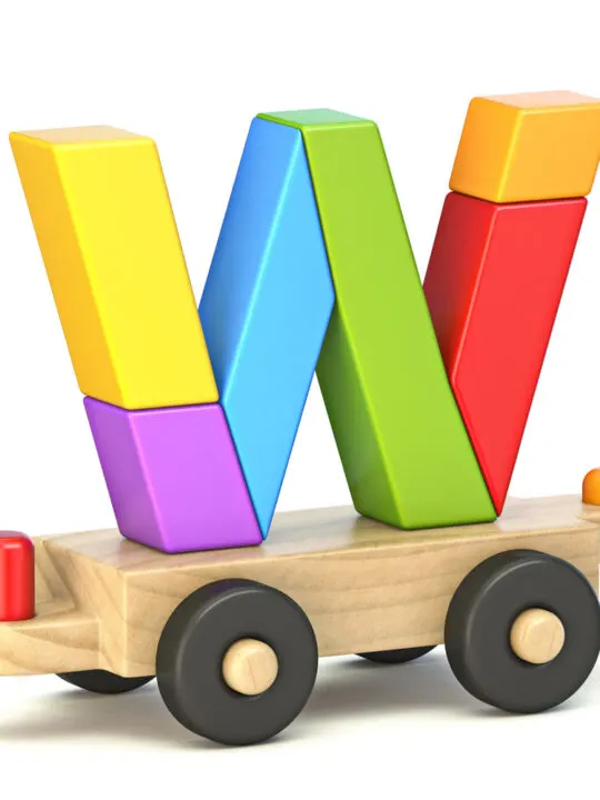 image of letter W built from wooden toys, on top of wooden train.