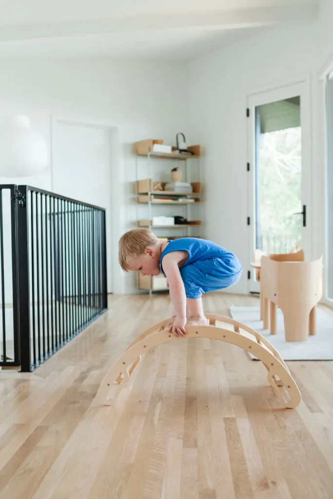 Image of toddler climbing on Montessori rocker toy.
