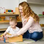 image of a teacher and baby in a nido Montessori classroom.
