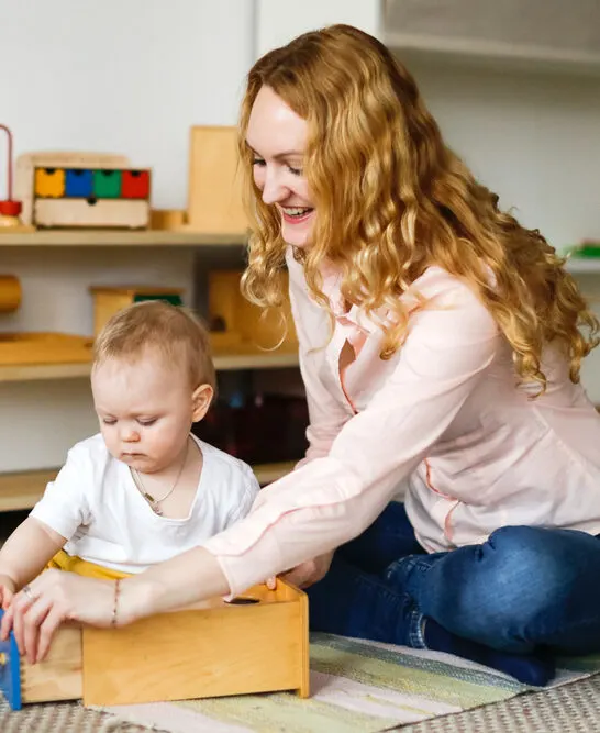 image of a teacher and baby in a nido Montessori classroom.